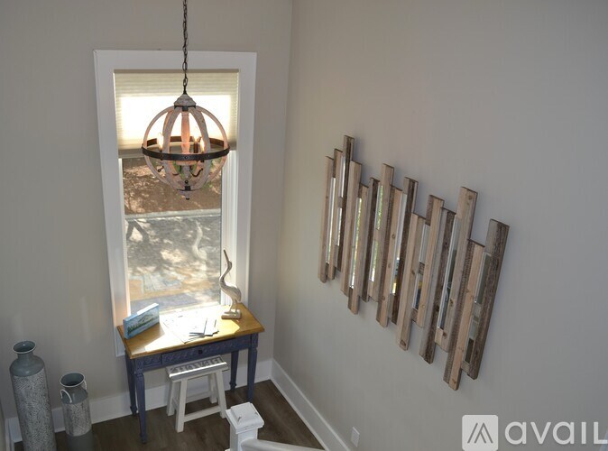 A room with a table, a window, and a wall hanging.