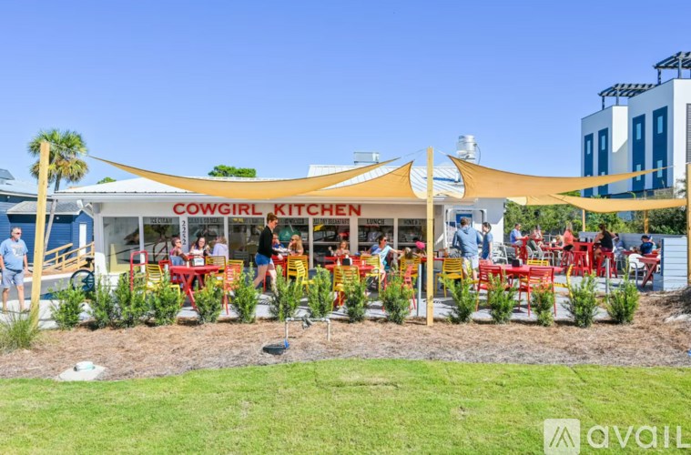 A restaurant named Cowgirl Kitchen has tables and chairs set up outside.