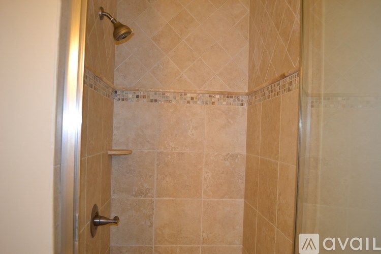A bathroom with a tiled shower and a door.