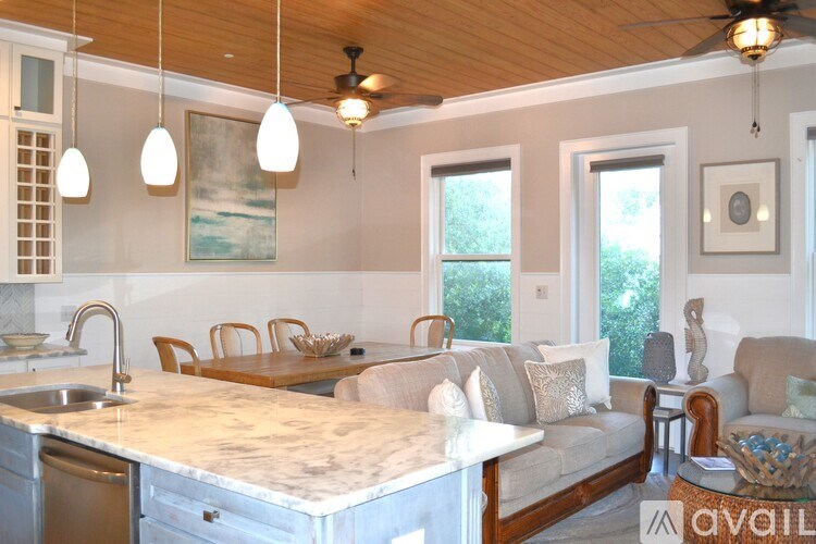 A kitchen with a marble countertop and a ceiling fan.