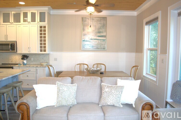 A living room with a couch and a painting on the wall.