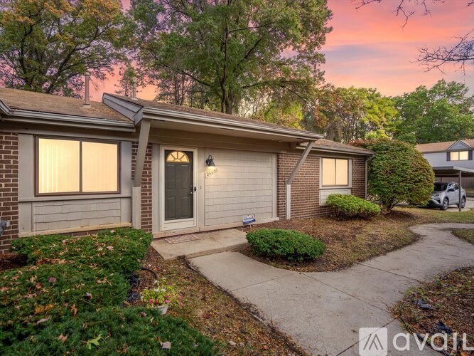 A house with a driveway and a car parked in front.