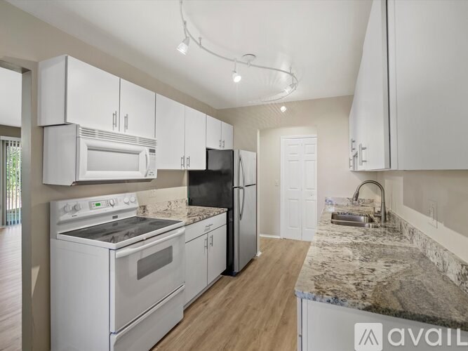 A kitchen with white appliances and cabinets.