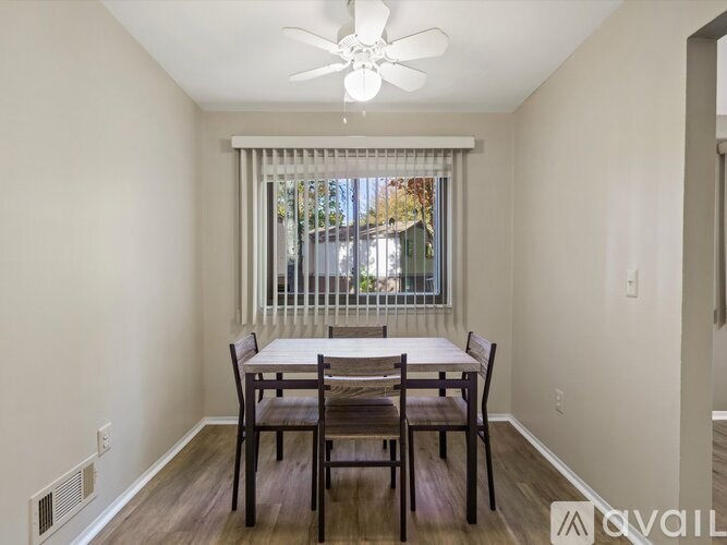 A dining room with a table and chairs.