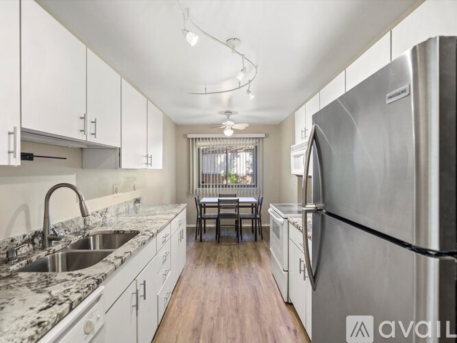 A kitchen with a marble countertop and stainless steel appliances.