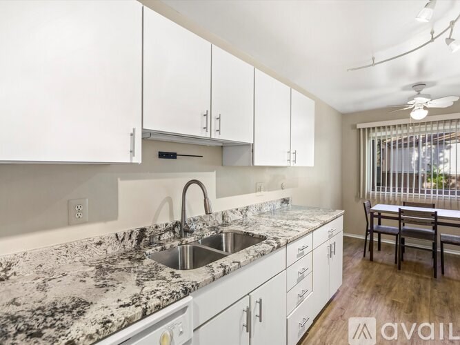 A kitchen with granite countertops and white cabinets.