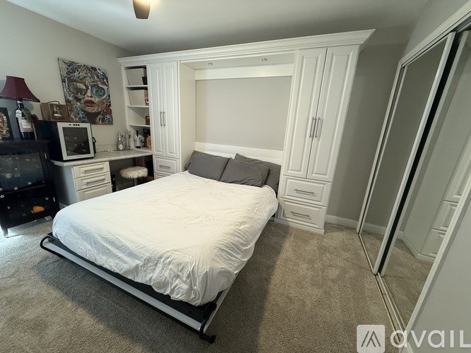 A bedroom with a bed, a microwave, and a television.