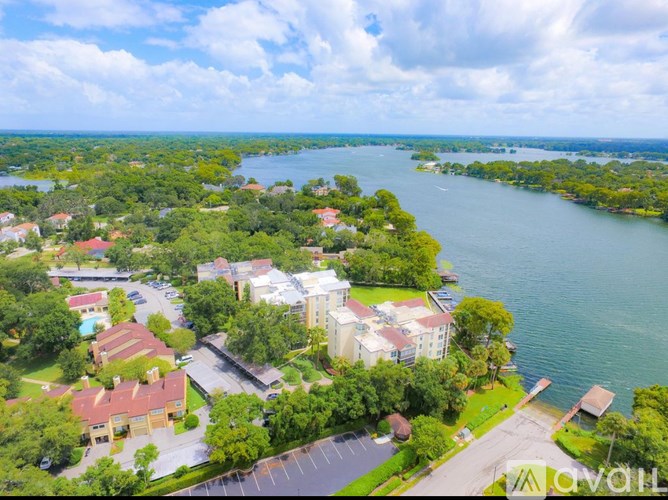 A bird's eye view of a residential area with a large body of water in the background.