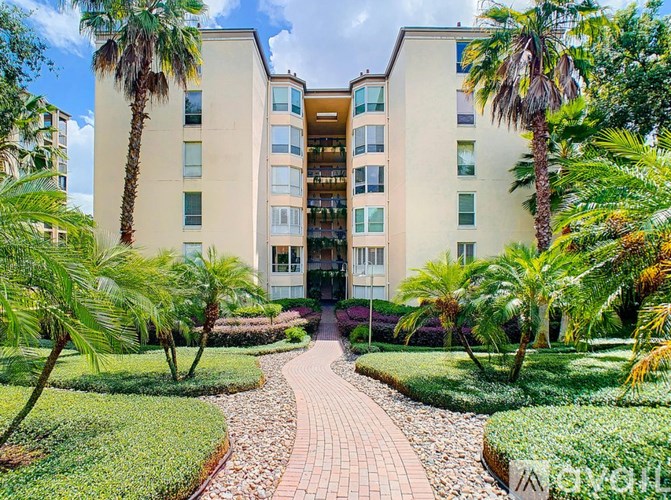 A building with a pathway in front of it surrounded by greenery.