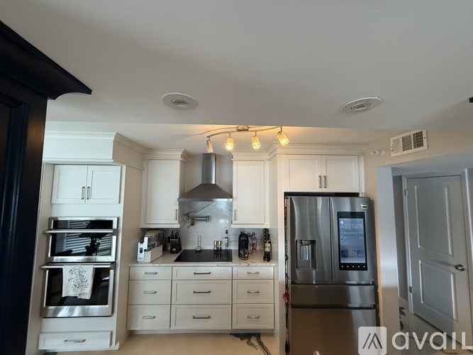 A kitchen with a refrigerator, oven, and sink.