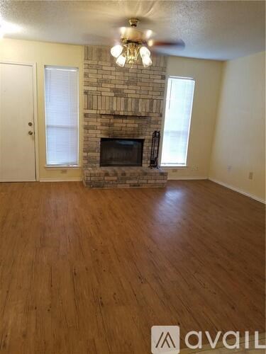 A room with a fireplace and wooden floors.