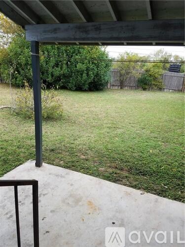 A concrete patio with a metal railing and a green pole.