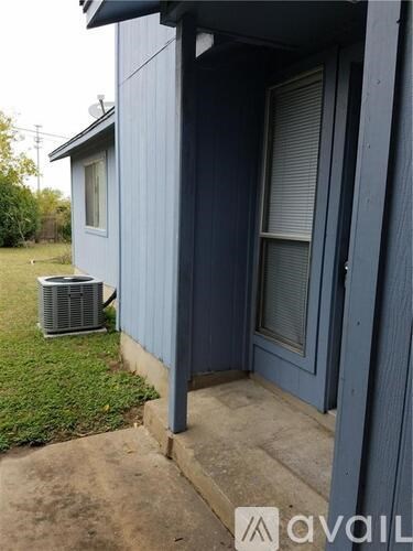 A house with a blue siding and a window with a closed grey shutter.