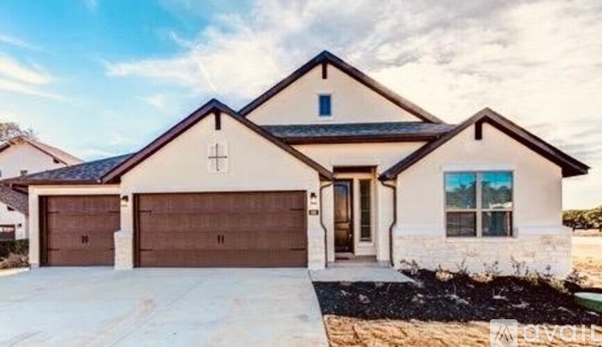 A two-story house with a garage and a driveway.