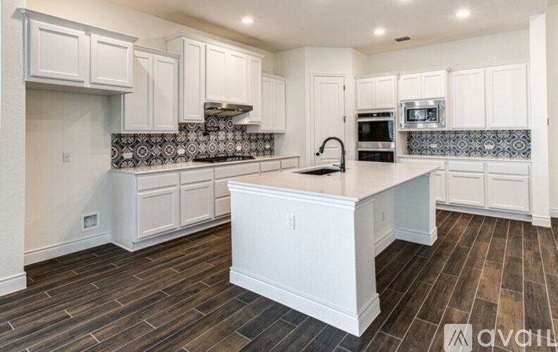 A kitchen with white cabinets and a wooden island.