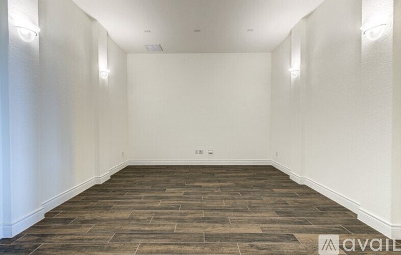 A room with wooden flooring and white walls.