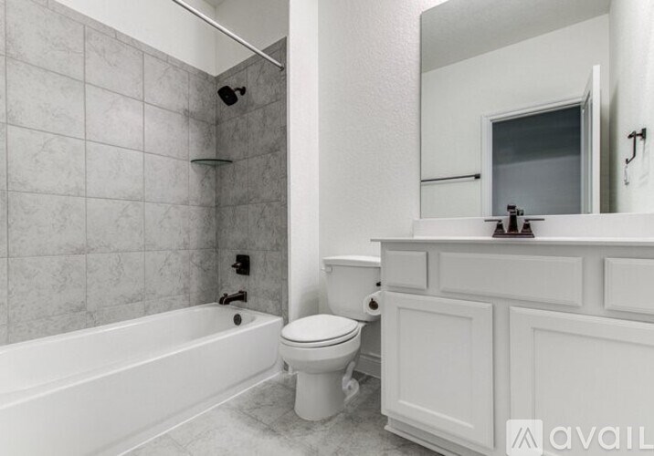 A white bathroom with a tub, toilet and sink.