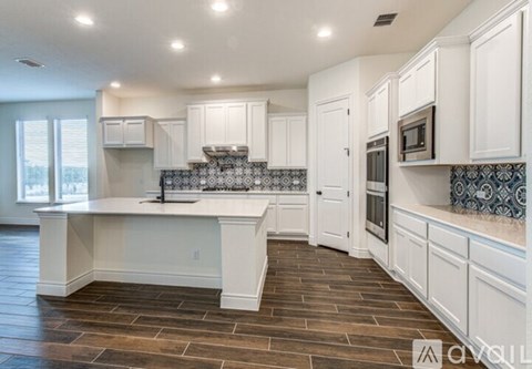A kitchen with white cabinets and a tile backsplash.
