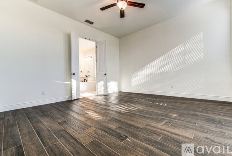 A room with wooden flooring and a ceiling fan.