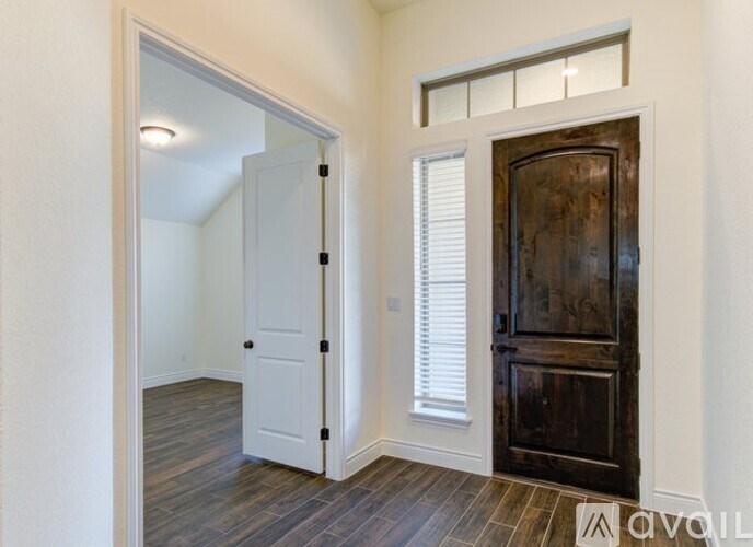 A room with a white door and a wooden door.
