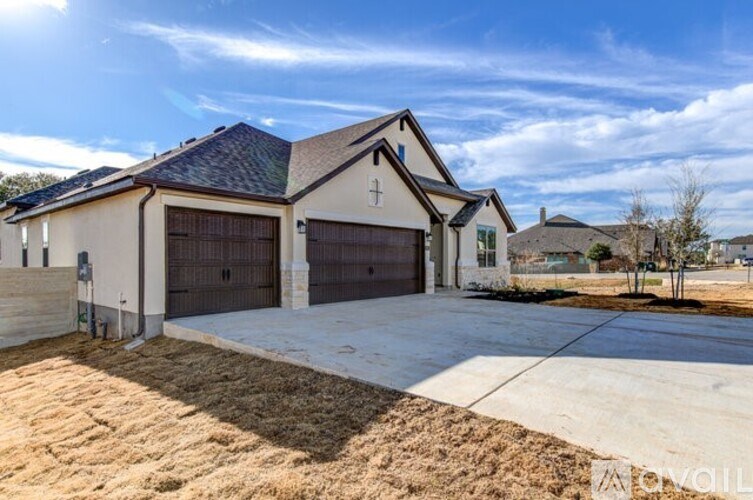 A house with a garage and a driveway in front of it.