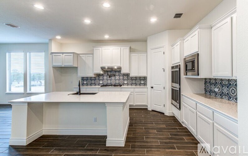 A kitchen with white cabinets and a wooden floor.