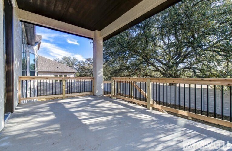 A balcony with a view of a house and trees.