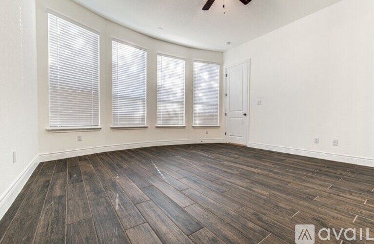 A room with wooden flooring and a ceiling fan.