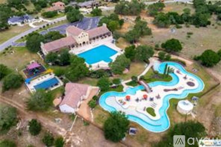 A large swimming pool with a slide is surrounded by a grassy area.