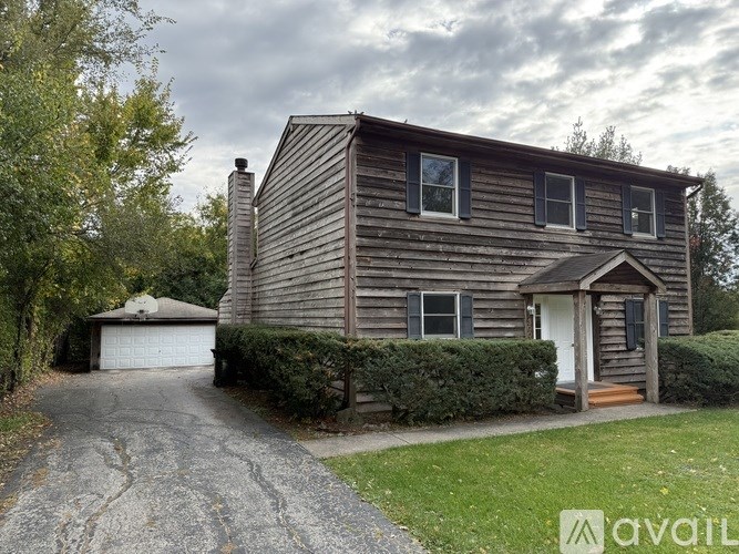 A house with a driveway and a garage is available for rent.