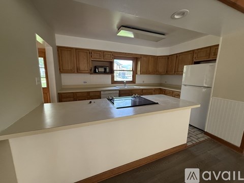 A kitchen with wooden cabinets and a white refrigerator.