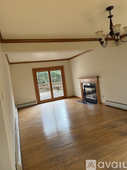 A room with wooden floors and a chandelier.