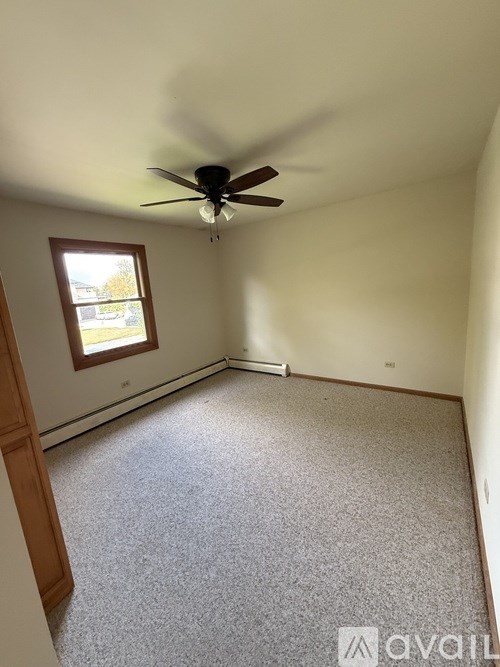 A room with a ceiling fan and a window.