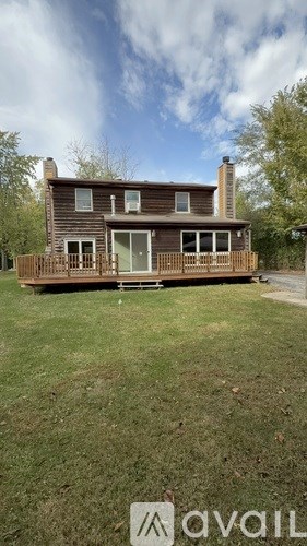 A wooden house with a porch is for sale.
