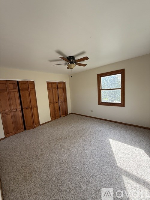 A room with a ceiling fan and a window.