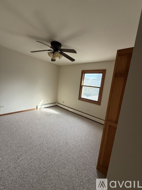A room with a ceiling fan and a window.