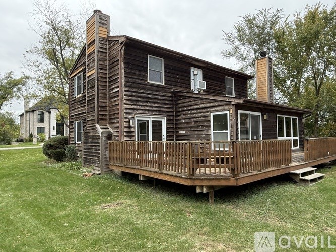 A wooden house with a deck in front.
