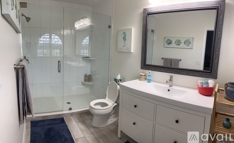 A bathroom with a toilet, sink, and mirror.
