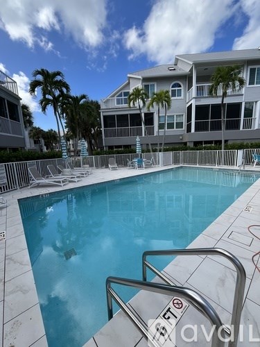 A swimming pool with a diving board and a building in the background.