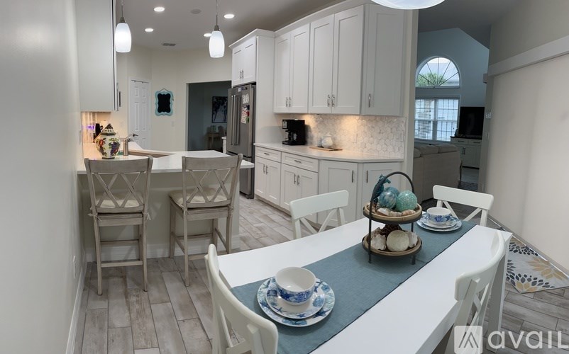 A kitchen with a table set for two with a blue runner.