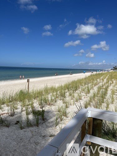A beach scene with a wooden railing in the foreground.