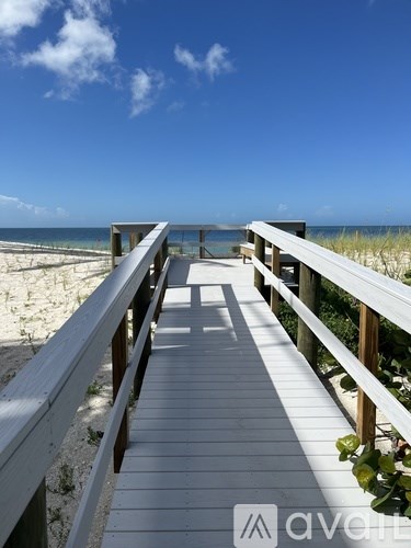 A wooden walkway leads to a beach.