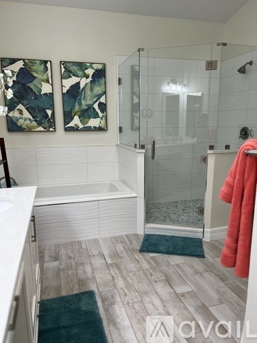 A bathroom with a white tub and a red towel.