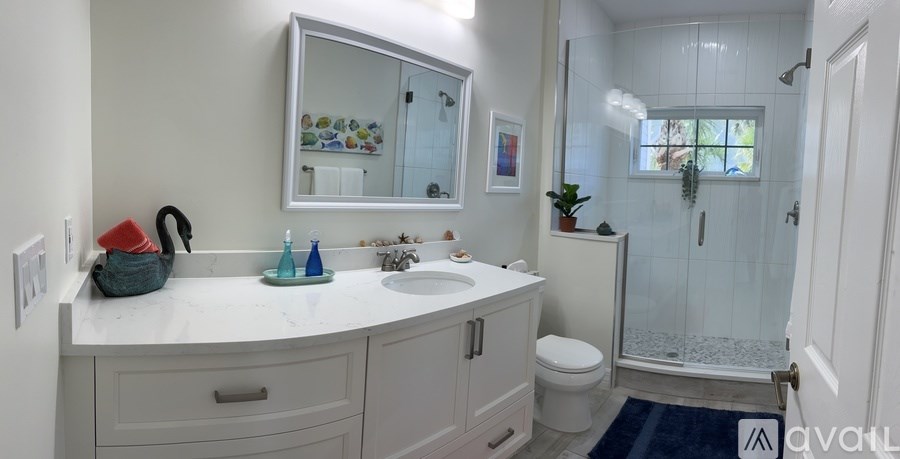 A bathroom with a white countertop and a white toilet.