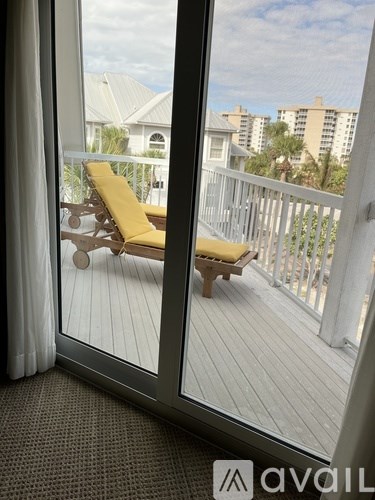 A balcony with a yellow chair and a view of buildings.