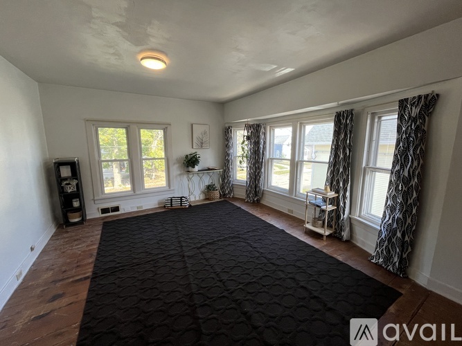 A room with a black carpet and a wooden floor.