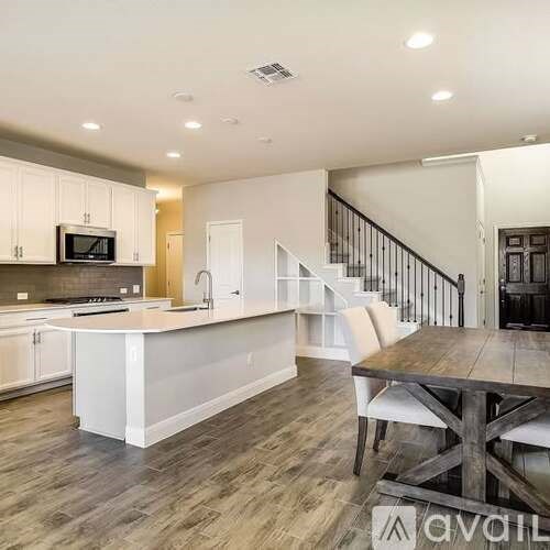A modern kitchen with white cabinets and a wooden island.