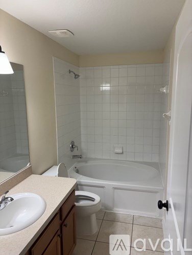 A bathroom with a white tub, sink, and toilet.