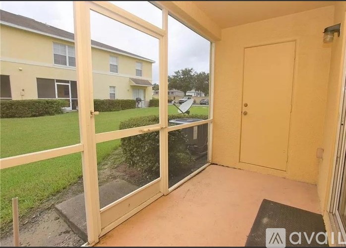A balcony with a door and a mat on the floor.