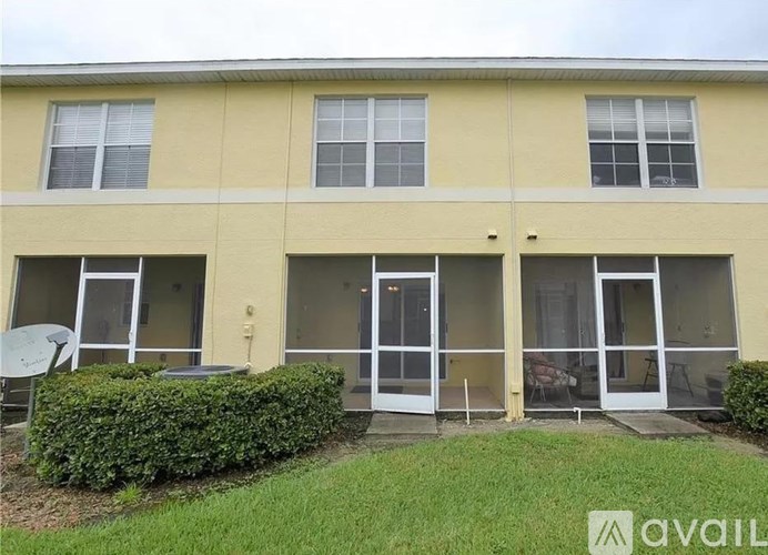 A building with a yellow facade and a green lawn in front.